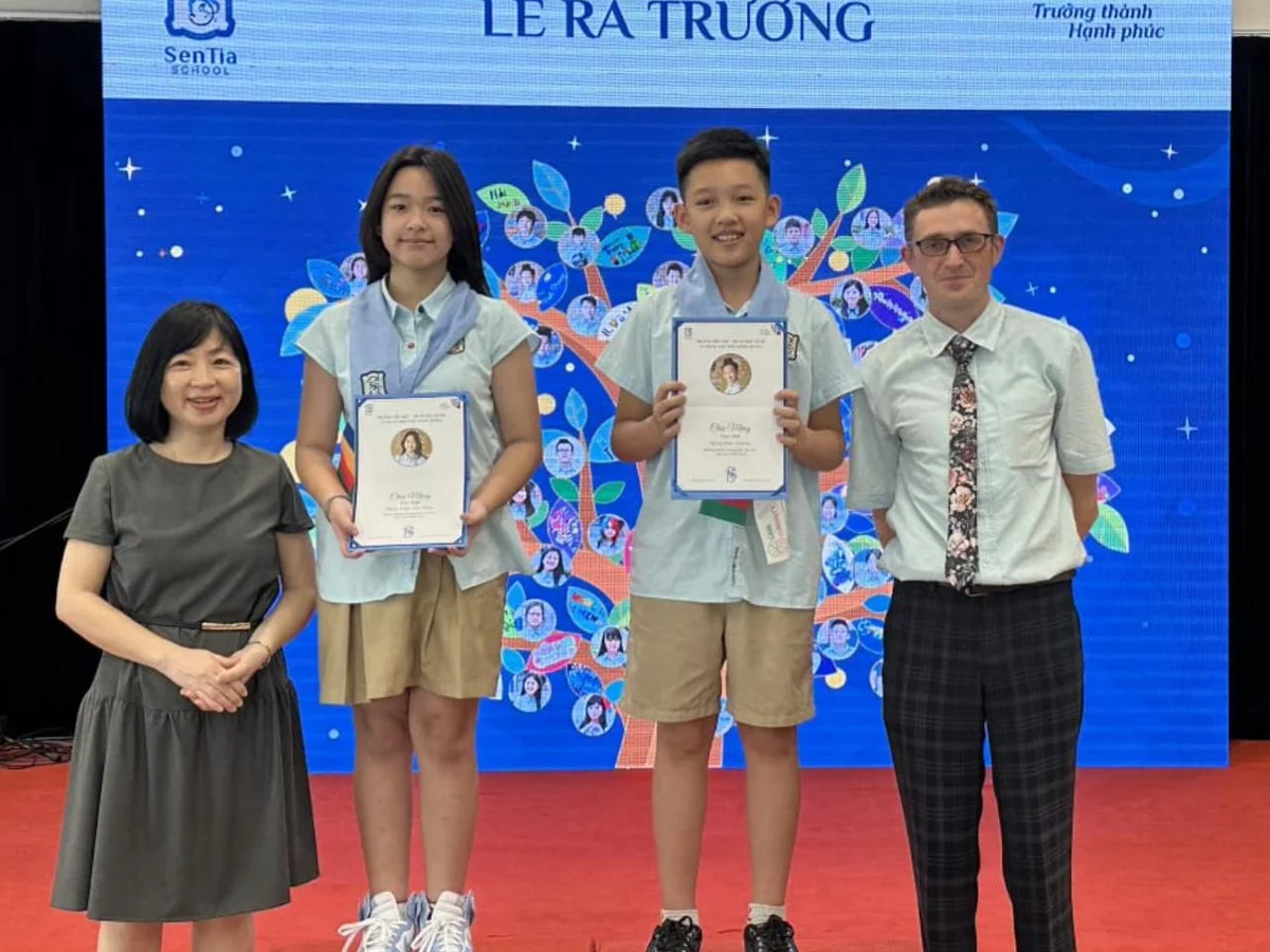 Quang nhận giấy chứng nhận hoàn thành lớp 7, cùng một bạn học và hai thầy cô