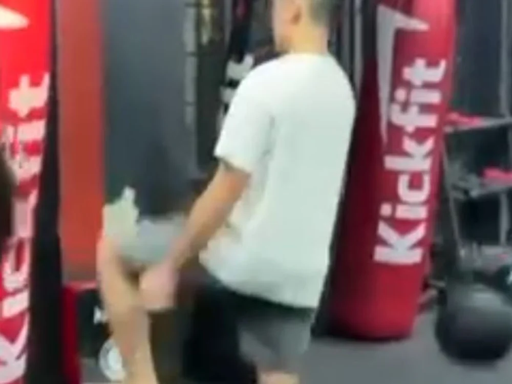 Quang lên đòn đầu gối vào bao cát trong phòng tập kickboxing