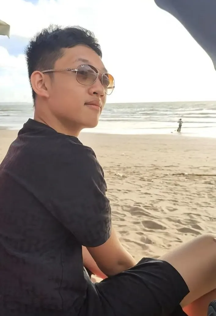 Quang ngồi trên bãi biển